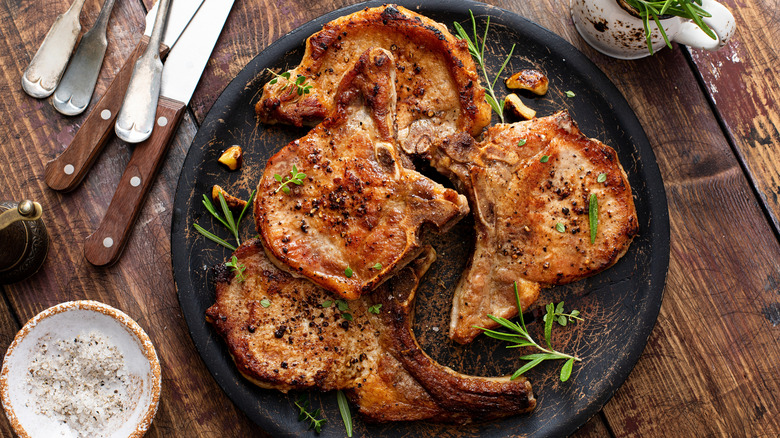 cooked pork chops with herbs on plate