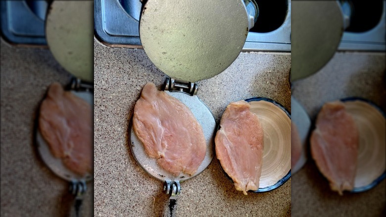 Chicken breast being flattened using a tortilla press