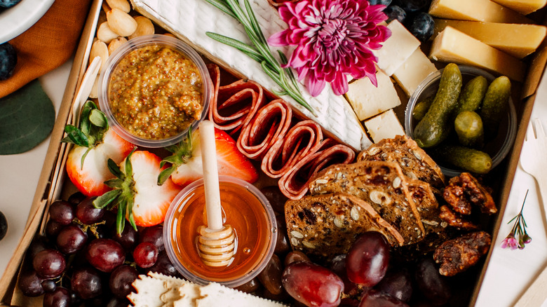 A charcuterie board of meat and cheese boxed to go