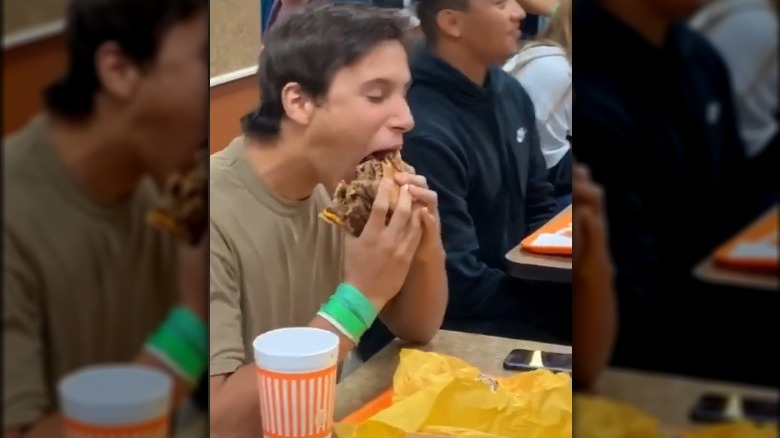 Ethan Mueller eats a burger