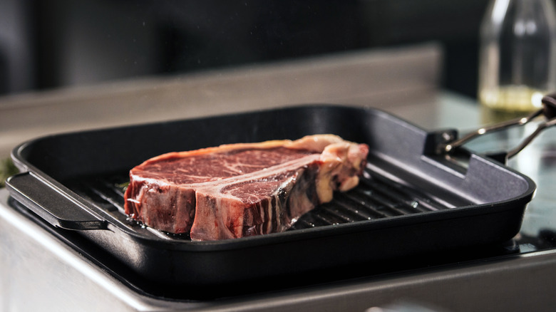 Raw steak in a griddle pan