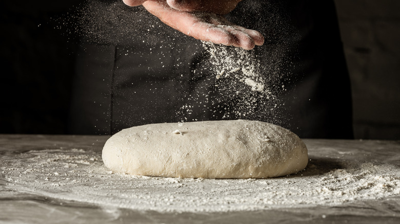 Pizza dough on floured surface