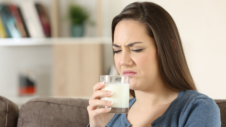 A woman sniffing milk