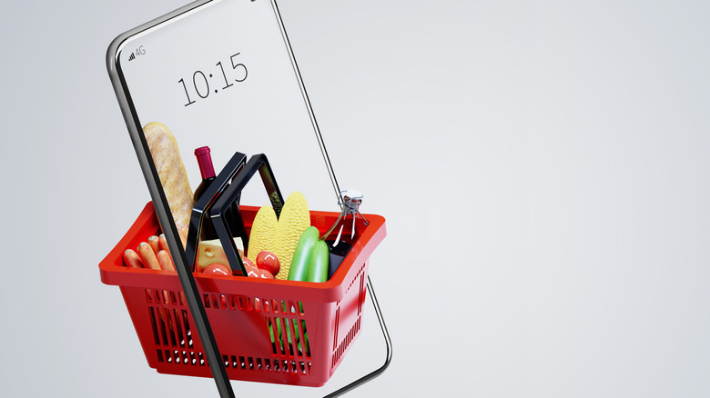 Chrome smartphone with red shopping basket of groceries