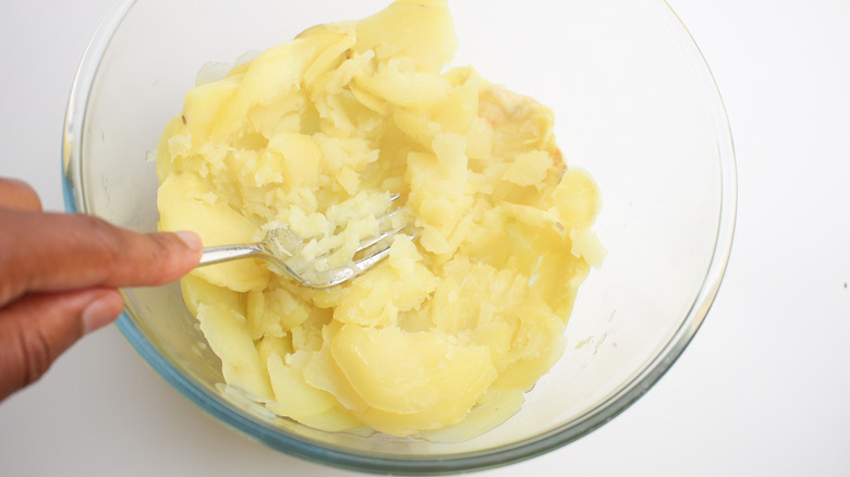 mashing potatoes in bowl