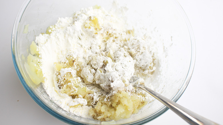 seasoning mashed potatoes in bowl