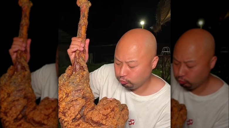 Man eating battered ostrich leg