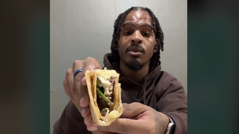 Keith Lee holding a chipotle taco