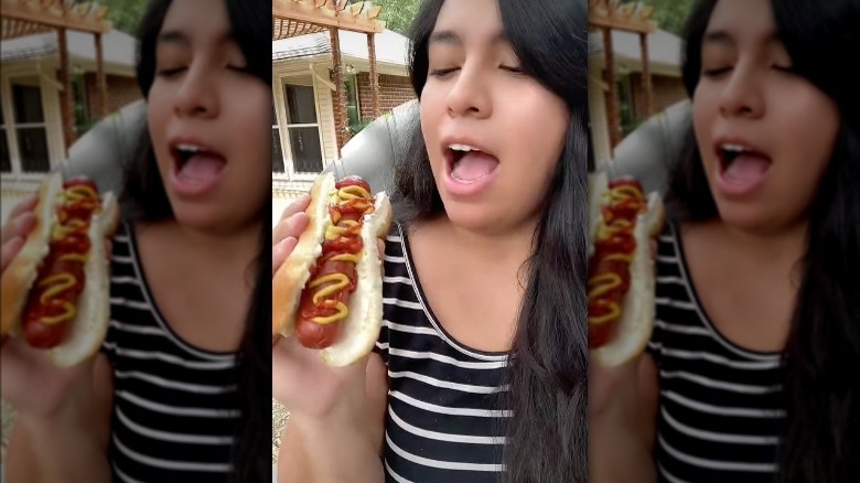 Woman holding hot dog