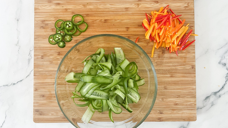 thinly sliced vegetables on board