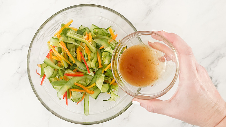 pouring ginger dressing on vegetables