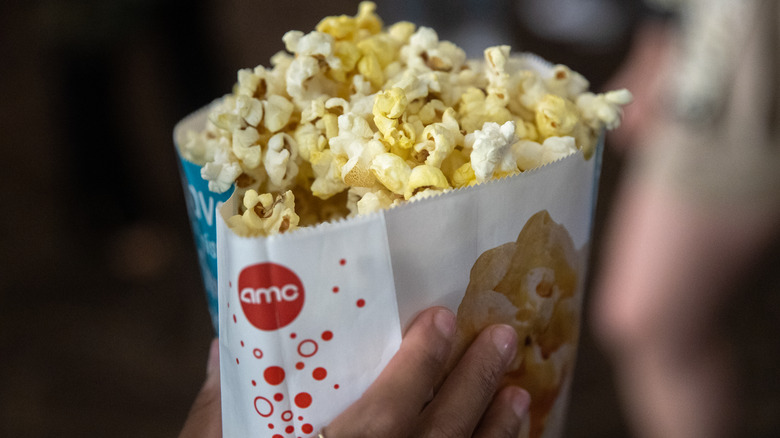 hand holding AMC popcorn