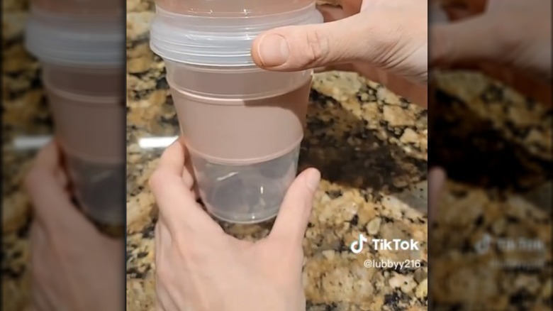 Hands holding plastic yogurt cup