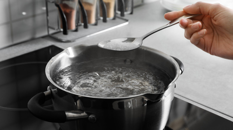 Sprinkling salt into boiling water