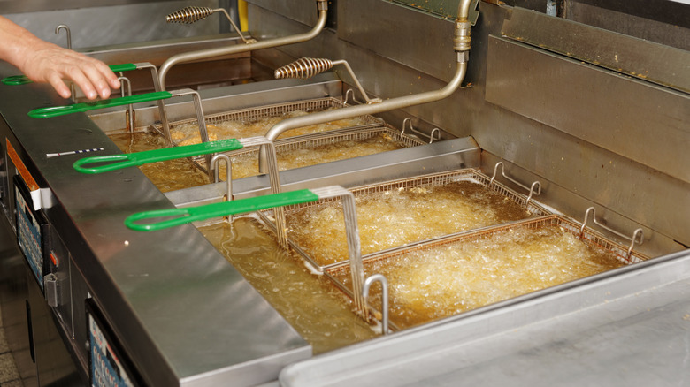 Baskets of food being cooked in a deep frier 