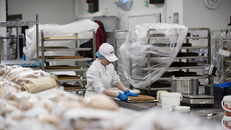 Costco employee slicing sheet cake