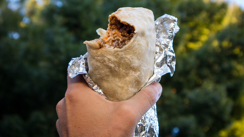 meat burrito with one bite taken out of it