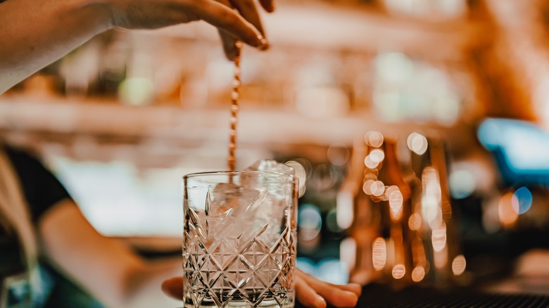 bartender mixing cocktail with spoon