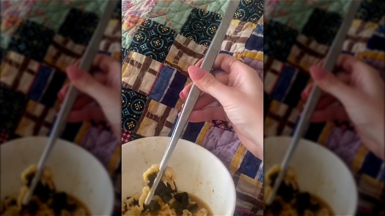 Person holding noodles with forceps