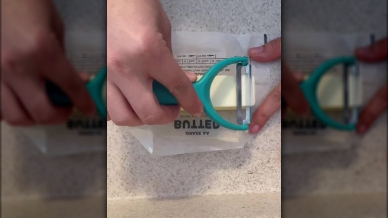 person slicing butter with a vegetable peeler