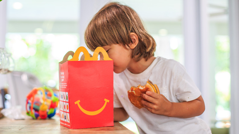 child looks into mcdonalds happy meal