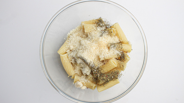 Seasoning, cheese, and pasta in a bowl