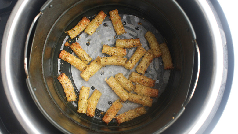 Cooked pasta in an air fryer basket