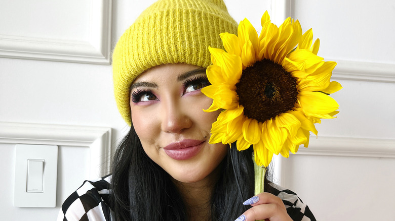 Ashley Yi smiling with sunflower