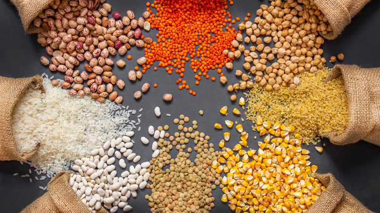 different kinds of beans and grains in burlap bags spilling out