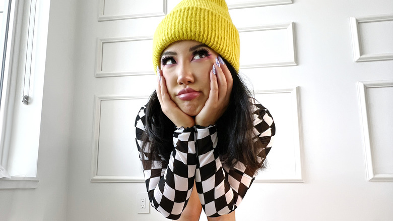 Ashley Yi posing in a yellow hat