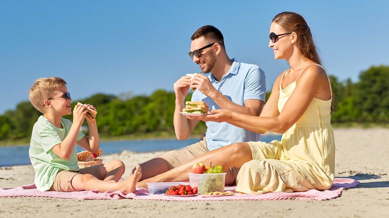 Family eating sandwiches at beach