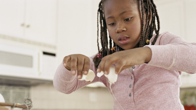 Child cracking an egg