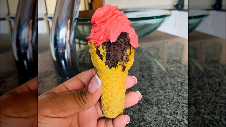 An ice cream cake cone with a bite taken out of it.