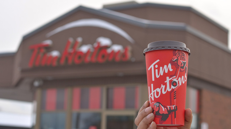 Person holding red Tim Hortons cup