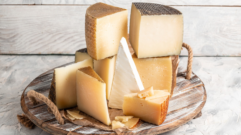 stack of cheese wedges on round wooden board