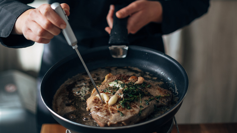 Chef taking temperature of meat