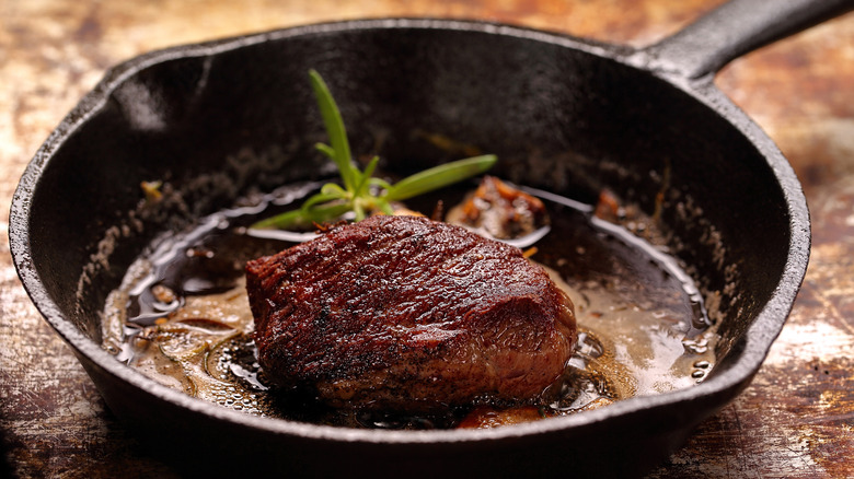 Steak cooking in cast iron pan