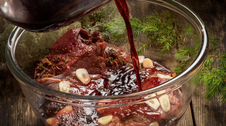 Pouring marinade over meat in bowl