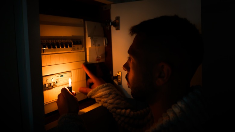 Man looking at fuse box in the dark 