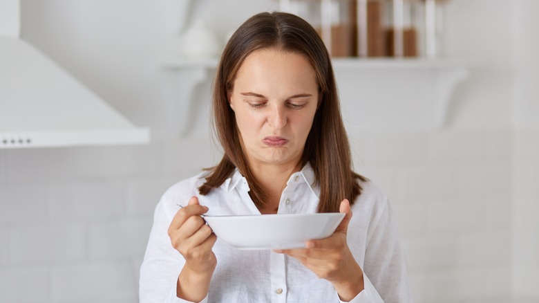 Woman looking at something gross on a plate