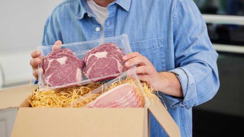 Man unpacking box of steak 