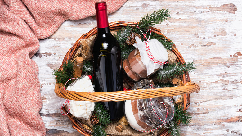 basket of pine boughs and glass jars of cocoa mix plus bottle of wine