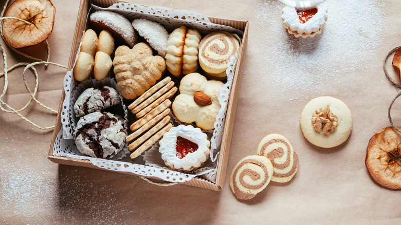 brown bakery box lines with paper doily and filled with assorted cookies