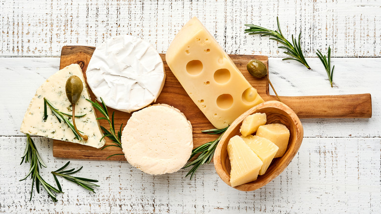 Various types of cheese on cutting board