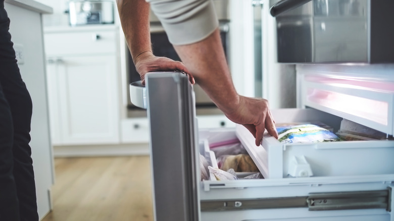 Person opening freezer door