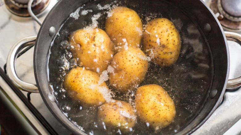 Whole potatoes boiling in pot