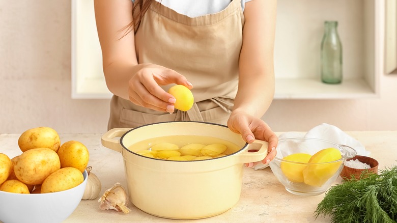 peeled potatoes in pot of water