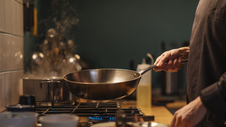 woman holding pan over stove