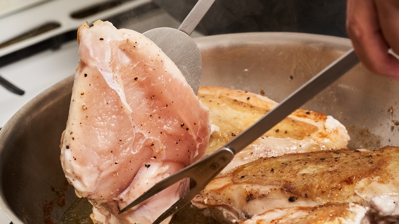 flipping chicken in skillet