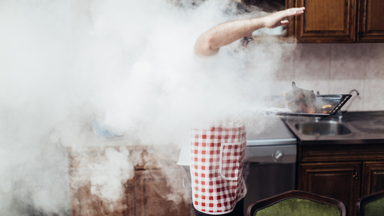 man caught in smoke in kitchen